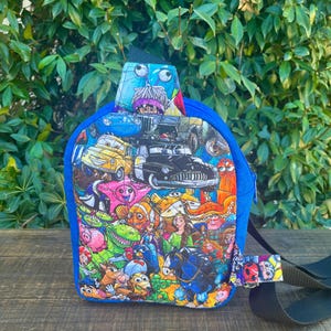 May include: A small blue backpack with a colorful print of various Disney characters, including Cars, Toy Story, and The Little Mermaid. The backpack has a single adjustable strap.