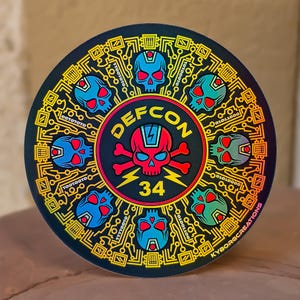 May include: A circular sticker featuring a central red skull and crossbones with the text DEFCON 34. The design is surrounded by eight smaller blue skulls and yellow circuit board patterns on a black background with binary code sequences.