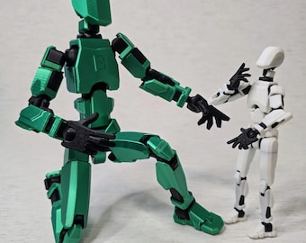 May include: Two articulated action figures, one green and one white, are posed in a friendly gesture. The green figure is kneeling with its right arm extended towards the white figure, which is standing with its left arm extended towards the green figure.