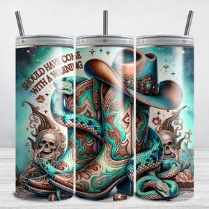 Peut inclure: Un gobelet turquoise et marron avec un motif de serpent et de bottes de cowboy. Le gobelet porte l'inscription "Should have come with a warning" sur le côté.