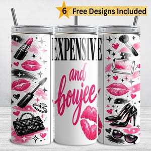 Pode incluir: Caneca branca com tampa e canudo prateados, decorada com ilustrações de maquiagem e moda. O design inclui batom, rímel, uma bolsa, saltos altos e o texto "EXPENSIVE and boujee" em rosa.