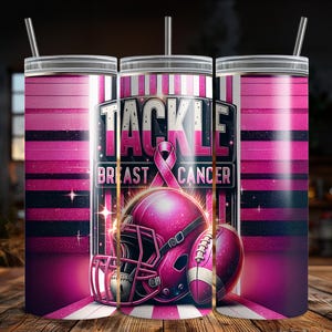 Puede incluir: Un vaso rosa con pajita, con un casco de f&uacute;tbol americano y un bal&oacute;n de f&uacute;tbol con las palabras "TACKLE BREAST CANCER". El dise&ntilde;o incluye una cinta rosa y un fondo a rayas rosas y negras.