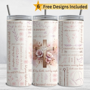 Op de afbeelding: Set van drie roestvrijstalen bekers van 590 ml met deksels en rietjes. De bekers hebben een bloemen- en kruisontwerp met inspirerende tekst in roze en bruine tinten. De tekst bevat zinnen als "Kind van God" en "Bedekt in genade".