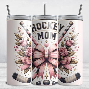 Puede incluir: Un vaso de color rosa claro con tapa y pajita plateadas, con las palabras "HOCKEY MOM" en negro. El dise&ntilde;o incluye palos de hockey cruzados, un lazo rosa, rosas y discos.