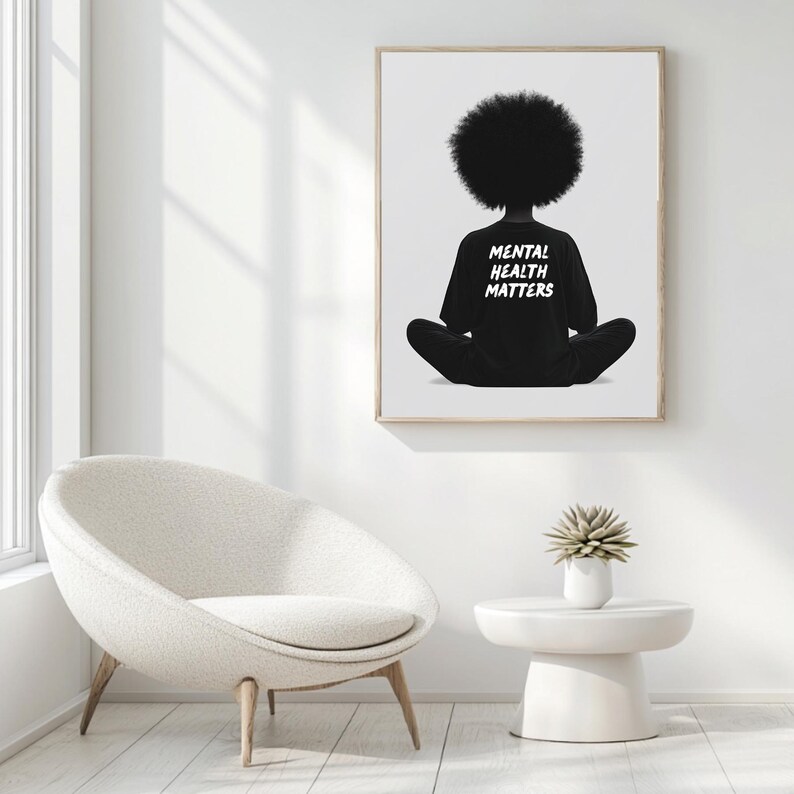 May include: Black and white illustration of a person sitting in a meditative pose with their back to the viewer. The person is wearing a black shirt with the text "Mental Health Matters" printed on the back. The illustration is framed and hanging on a white wall.