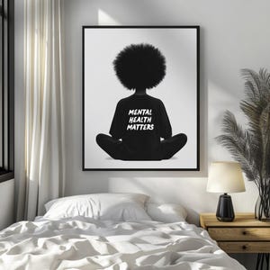 May include: Black and white illustration of a person sitting in a meditative pose with their back to the viewer. The person is wearing a black t-shirt with the words "Mental Health Matters" printed in white.