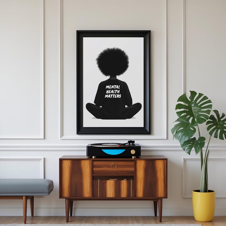 May include: Black and white illustration of a person with an afro sitting in a meditative pose. The person is wearing a black shirt with the text "Mental Health Matters" printed on the back.