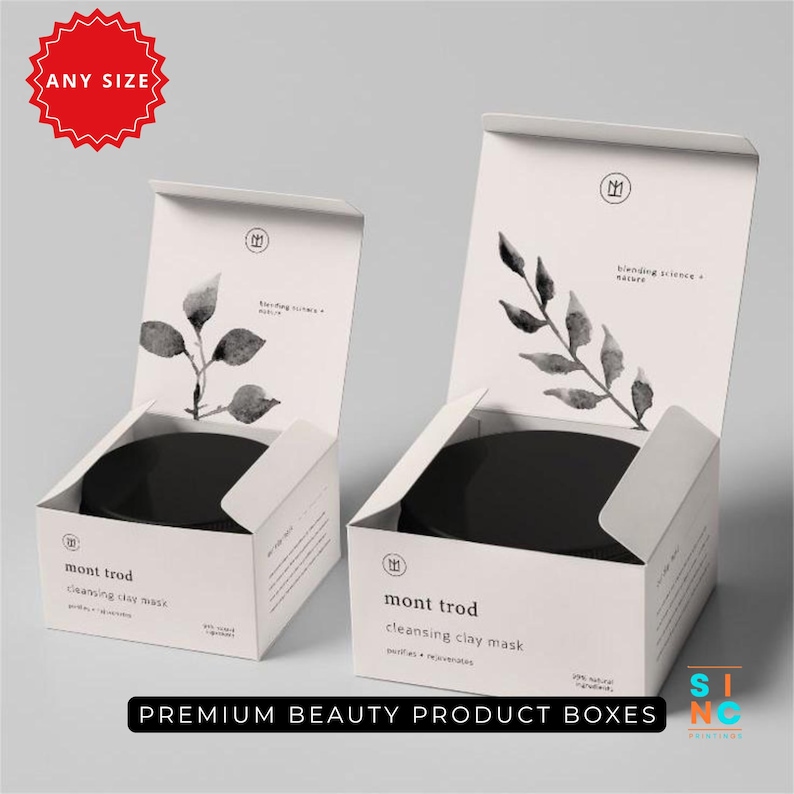 Puede incluir: Dos cajas de productos blancas con tapas abiertas, cada una con un tarro negro. Las cajas presentan un dise&ntilde;o minimalista con una ilustraci&oacute;n bot&aacute;nica y el texto "mont trod cleansing clay mask". Las cajas est&aacute;n etiquetadas como "Premium Beauty Product Boxes".