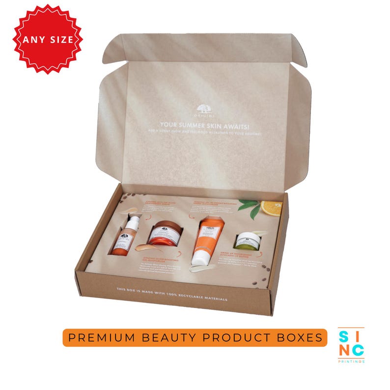 Puede incluir: Caja de cart&oacute;n abierta con productos de belleza, incluyendo tubos, tarros y botellas naranjas y blancos. La caja lleva la etiqueta "Your Summer Skin Awaits!" y "Premium Beauty Product Boxes."