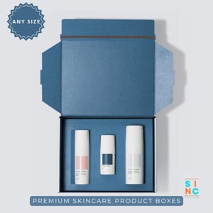 Puede incluir: Caja de productos para el cuidado de la piel azul abierta con tres botellas cil&iacute;ndricas blancas. La caja tiene un interior y un exterior azules a juego. El texto "ANY SIZE" est&aacute; en una insignia azul en la esquina superior izquierda. El texto "PREMIUM SKINCARE PRODUCT BOXES" est&aacute; en la parte inferior.