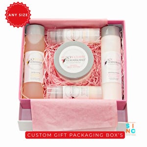 Puede incluir: Una caja de regalo rosa llena de productos de belleza, incluyendo botellas y un tarro de manteca corporal. Los productos est&aacute;n dispuestos sobre papel triturado rosa. La caja tiene el texto "CUSTOM GIFT PACKAGING BOX'S".