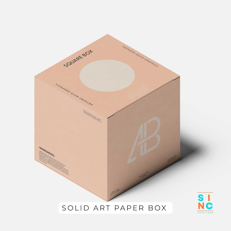Puede incluir: Una caja cuadrada de papel de arte s&oacute;lido de color melocot&oacute;n con un c&iacute;rculo blanco en la parte superior. La caja presenta el texto "SQUARE BOX" y "ANTHONY BOYD GRAPHICS". La caja tambi&eacute;n tiene las letras "AB" en un dise&ntilde;o blanco. El texto "SOLID ART PAPER BOX" est&aacute; en la parte inferior.
