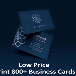 Può includere: Biglietti da visita blu scuro con un design floreale argentato e il nome "NUCIFERA" stampato sulla carta superiore. La carta inferiore mostra le informazioni di contatto e il nome "CASSANDRA Executive Director". Il testo "Low Price Print 800+ Business Cards" è in basso.