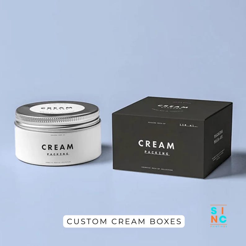 Puede incluir: Un tarro de crema blanco con tapa plateada y una caja negra con las palabras "CREAM PACKING" en blanco. El texto "CUSTOM CREAM BOXES" est&aacute; en la parte inferior de la imagen.