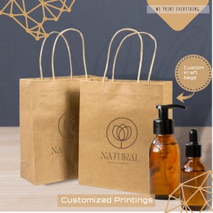 Puede incluir: Dos bolsas de la compra de papel kraft marrón con asas blancas y un logotipo que dice "NATURAL" y "simple & organic". Dos botellas de vidrio ámbar con bombas y cuentagotas negros están delante de las bolsas. También se ve el texto "WE PRINT EVERYTHING" y "Custom Kraft bags".