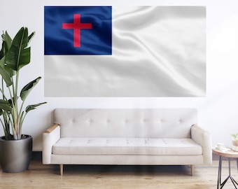 May include: A white and blue Christian flag with a red cross in the center. The flag is hanging on a white wall above a white couch.