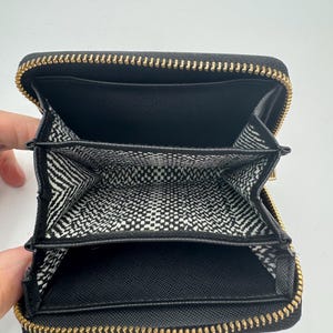 Puede incluir: Una taza de cer&aacute;mica blanca con un asa negra y el texto "But First, Coffee" en negro, en negrita. La taza est&aacute; sobre una superficie blanca.