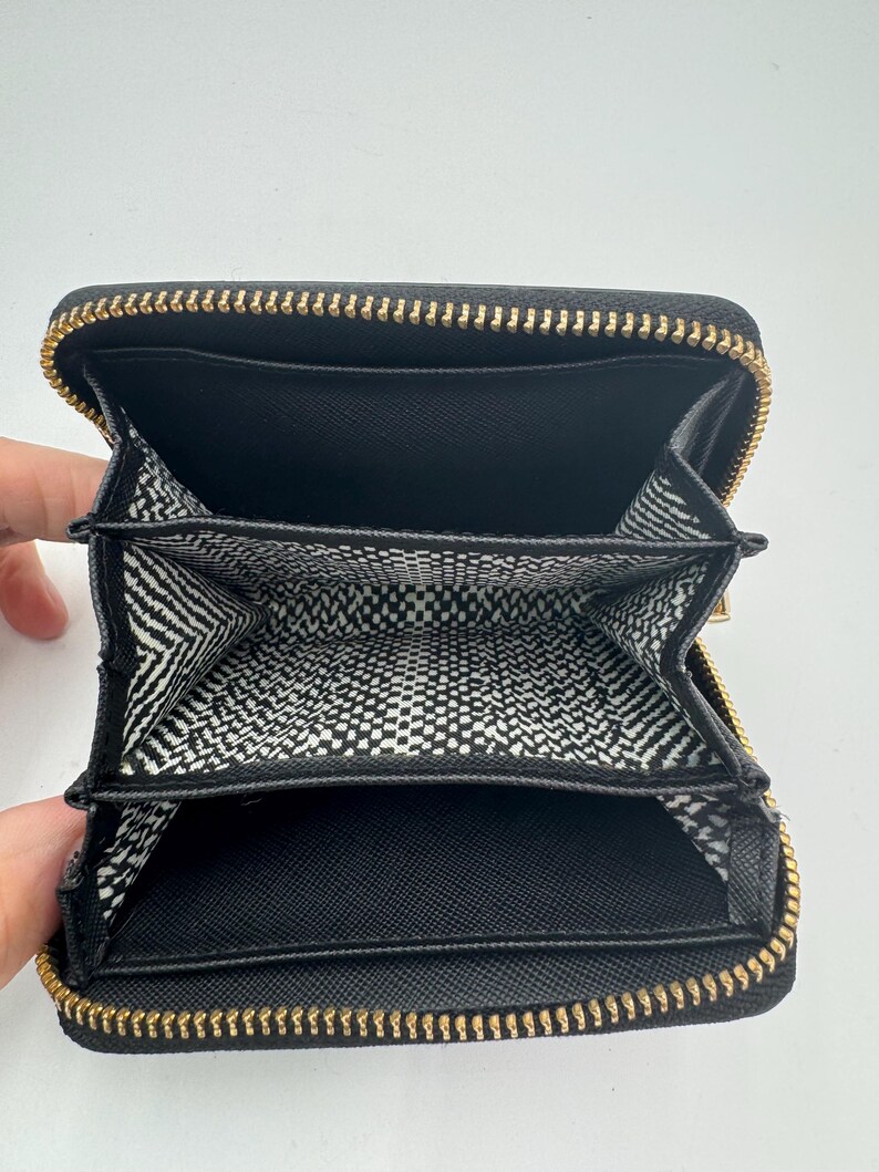 Puede incluir: Una taza de cer&aacute;mica blanca con un asa negra y el texto "But First, Coffee" en negro, en negrita. La taza est&aacute; sobre una superficie blanca.