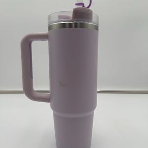 Op de afbeelding: Een lavendelkleurige ge&iuml;soleerde beker met een handvat en een doorzichtig deksel. De beker heeft een paarse flip-top deksel en een bijpassend handvat. De beker is ontworpen om dranken koud of warm te houden. De beker is ongeveer 25 cm hoog.