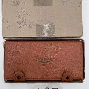 May include: A rectangular brown textured case with two snap closures and the text TACRO 3662 printed on the front. The case is housed in a cardboard box with the text TACRO Made in Western Germany and the number 3662 printed on the lid.