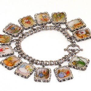 May include: A silver-toned metal charm bracelet featuring twelve rectangular charms, each displaying a unique, colorful illustration of Peter Rabbit characters and scenes, connected by a sturdy chain with a toggle clasp closure.