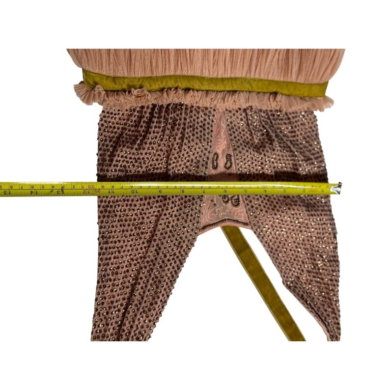 May include: A vintage, blush-colored garment with intricate beadwork and a pleated top. The garment features a gold ribbon and measures approximately 15 inches in length. The design includes decorative embroidery.