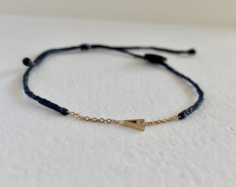 Gold initial adjustable bracelet; made with 14k solid gold letter and chain; on waxed and braided thread; finished with square knot