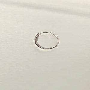 May include: A simple silver ring with a flat band.