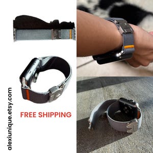 Op de afbeelding: Grijze Apple Watch band met een zilveren sluiting en oranje accent. De band wordt in verschillende weergaven getoond, inclusief om een pols. De tekst "alexiunique.etsy.com" is zichtbaar.
