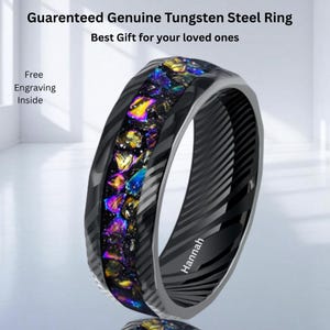 Puede incluir: Un anillo de acero de tungsteno negro con una incrustación colorida y texturizada. El anillo tiene un exterior estampado y el nombre "Hannah" grabado en el interior. El texto en la imagen dice "Guaranteed Genuine Tungsten Steel Ring" y "Free Engraving Inside."