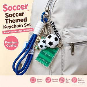 Könnte beinhalten: Fußball-Themen-Schlüsselanhänger-Set mit zwei Fußball-Anhängern, einem Miniatur-Fußballfeld und einem blauen Schlüsselband. Das Set enthält den Text "Soccer Themed Keychain Set" und "Show Your Love for the Game!"