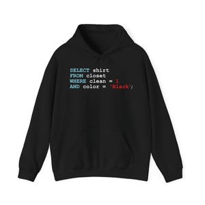 Op de afbeelding: Zwarte hoodie met een voorzak en een capuchon met trekkoord. De hoodie toont tekst in een programmeercode-stijl: "SELECT shirt FROM closet WHERE clean = 1 AND color = 'Black';".