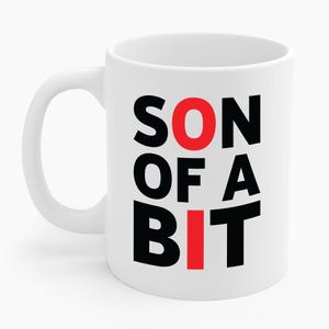 May include: White ceramic mug with the text "SON OF A BIT" in black and red block letters. The mug has a curved handle and a glossy finish. The text is stacked vertically, with the word "SON" at the top.