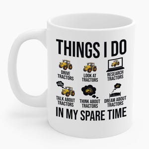 以下が含まれることがあります： 「THINGS I DO」の文字とトラクターのイラストが描かれた白いセラミックマグカップ。「DRIVE TRACTORS」、「LOOK AT TRACTORS」、「RESEARCH TRACTORS」、「TALK ABOUT TRACTORS」、「THINK ABOUT TRACTORS」、「DREAM ABOUT TRACTORS」の文字が描かれています。