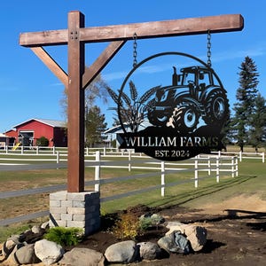 May include: A black metal sign featuring a tractor silhouette and wheat stalks. The sign is suspended from a wooden post and displays the text "William Farms Est. 2024".