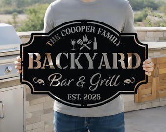 Könnte beinhalten: Schwarzes Metallschild mit dem Text "The Cooper Family Backyard Bar & Grill EST. 2025". Das Schild hat einen dekorativen Rand und Illustrationen eines Weinglases, Grillwerkzeugs und einer Flasche.