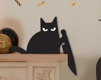 May include: A black cat-shaped Halloween decoration with white eyes, holding a knife. The cat is perched on a white shelf, with candy and pumpkins in the background. A fun and spooky addition to any Halloween decor.