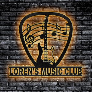 May include: Black metal sign with a guitar and musical notes inside a pick shape. The sign reads "Loren's Music Club".