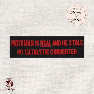 May include: A black rectangular magnet or sticker with the text "MOTHMAN IS REAL AND HE STOLE MY CATALYTIC CONVERTER" in red. The magnet is 10" x 3" and has a circular sticker label. The background is a textured white.