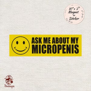 May include: A yellow rectangle magnet or sticker with the text "ASK ME ABOUT MY MICROPENIS" in black. A smiling face is on the left. The magnet is 25.4 cm x 7.6 cm.
