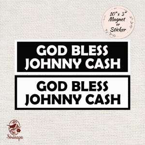 May include: Two rectangular magnets or stickers, each with the text "GOD BLESS JOHNNY CASH" in white on a black background. The dimensions are 10" x 3". The image also includes a logo and text indicating it's a magnet or sticker.