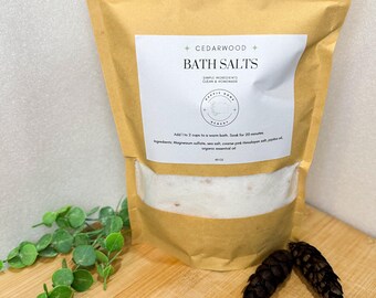 Może przedstawiać: Brązowa papierowa torba wypełniona białymi solami do kąpieli. Torba ma białą etykietę z tekstem "CEDARWOOD BATH SALTS" i "SIMPLE INGREDIENTS CLEAN & HOMEMADE".