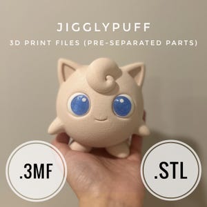 以下が含まれることがあります： 大きな青い目とカールした上部が特徴の、明るいピンク色の3DプリントされたJigglypuffフィギュア。画像には「JIGGLYPUFF」と「3D PRINT FILES（PRE-SEPARATED PARTS）」というテキストが含まれています。ファイルタイプ.3MFと.STLも表示されています。