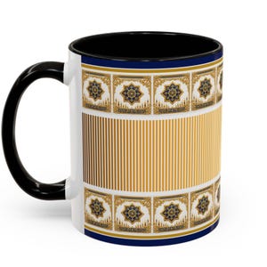 Op de afbeelding: Witte keramische mok met een zwarte handgreep en binnenkant. De mok heeft een goud-blauw geometrisch patroon met verticale gouden strepen. Een marineblauwe band accentueert de boven- en onderkant van de mok.