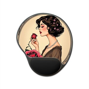 Può includere: Un tappetino per mouse con un'illustrazione in stile vintage di una donna che annusa una rosa rossa. La donna ha i capelli scuri con fiori rosa e indossa un abito marrone e una collana di perle. Il tappetino ha un poggiapolsi nero.