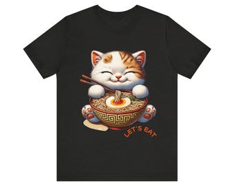 May include: A black t-shirt with a white and orange cat eating ramen noodles from a bowl. The cat is smiling and the text "Let's Eat" is below the bowl.