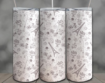 May include: Three white travel tumblers with a repeating pattern of Parisian icons in gray. The design includes the Eiffel Tower, bicycles, pastries, and street lamps. Each tumbler has a silver lid and a straw.