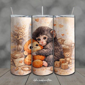 May include: A cylindrical tumbler featuring a watercolour-style illustration of a dark-furred monkey hugging an orange plush monkey. The design includes a vase of flowers, a gift box, an envelope with a heart, a basket, a teddy bear, and alphabet blocks.