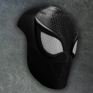 May include: A black 3D printed mask with a spider-web design and a white mesh over the eyes.