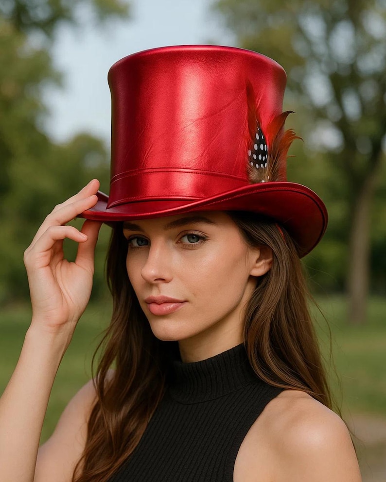 May include: A shiny red top hat with a feather accent. The hat has a tall, cylindrical crown and a wide brim. The feather is brown with white polka dots. The hat is worn by a person wearing a black turtleneck.